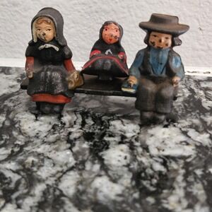 a set of‎ vintage cast iron Amish 3 figurines on a bench